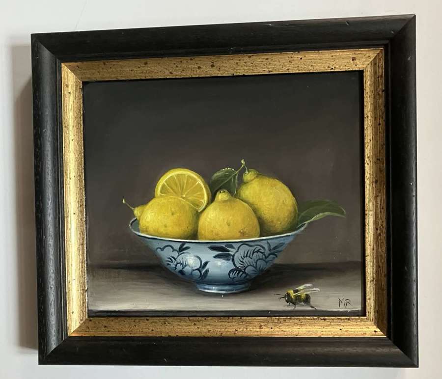 Lemons in a bowl with a bee